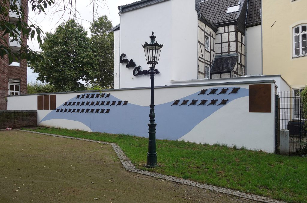 Die Närrische Ruhmesmeile, eine weiß blaue Wand, wo alle Pritschen des Prinzenpaare befestig sind. Im Vordergrund steht eine urige Altstadtlaterne